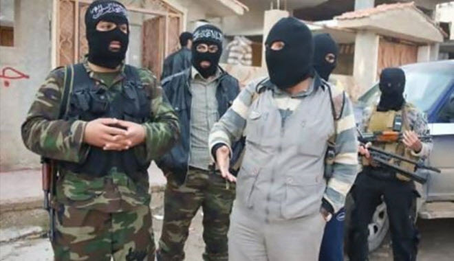 الرجل الذي يسمي نفسه الشيخ أبو أحمد إلى جانب عضو آخر في جبهة النصرة